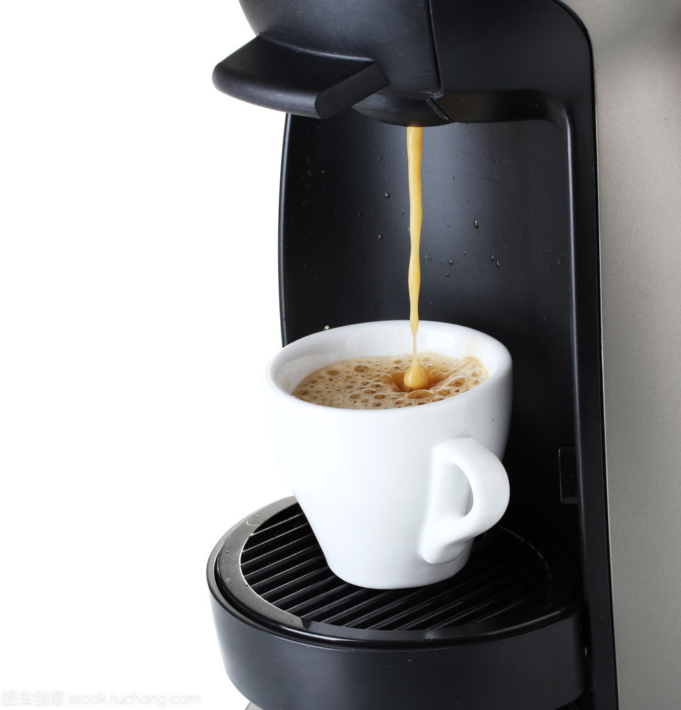 澆上白色隔離的杯中的咖啡的咖啡機